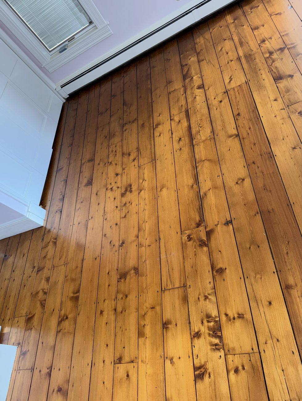 Refinished pine plank floor with rich amber color