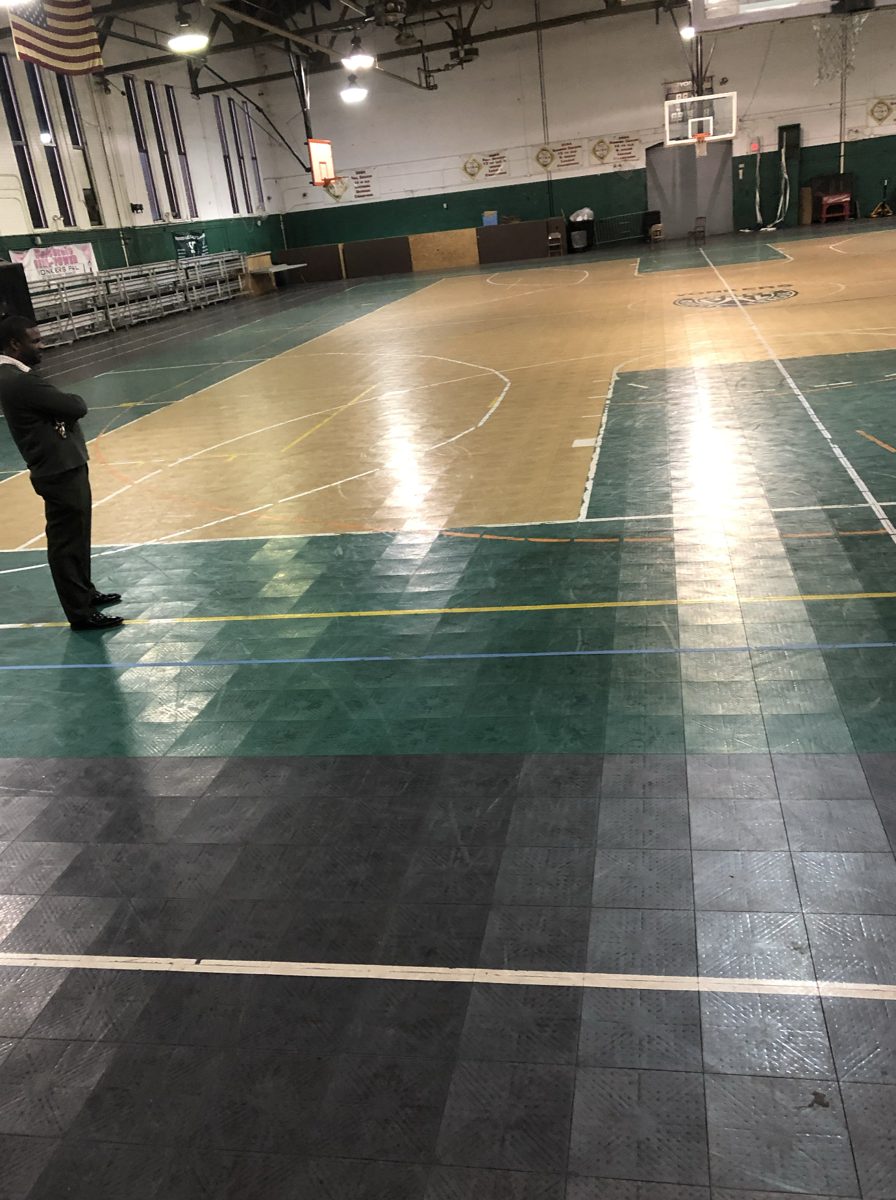 The worn tile court with a person standing at the edge
