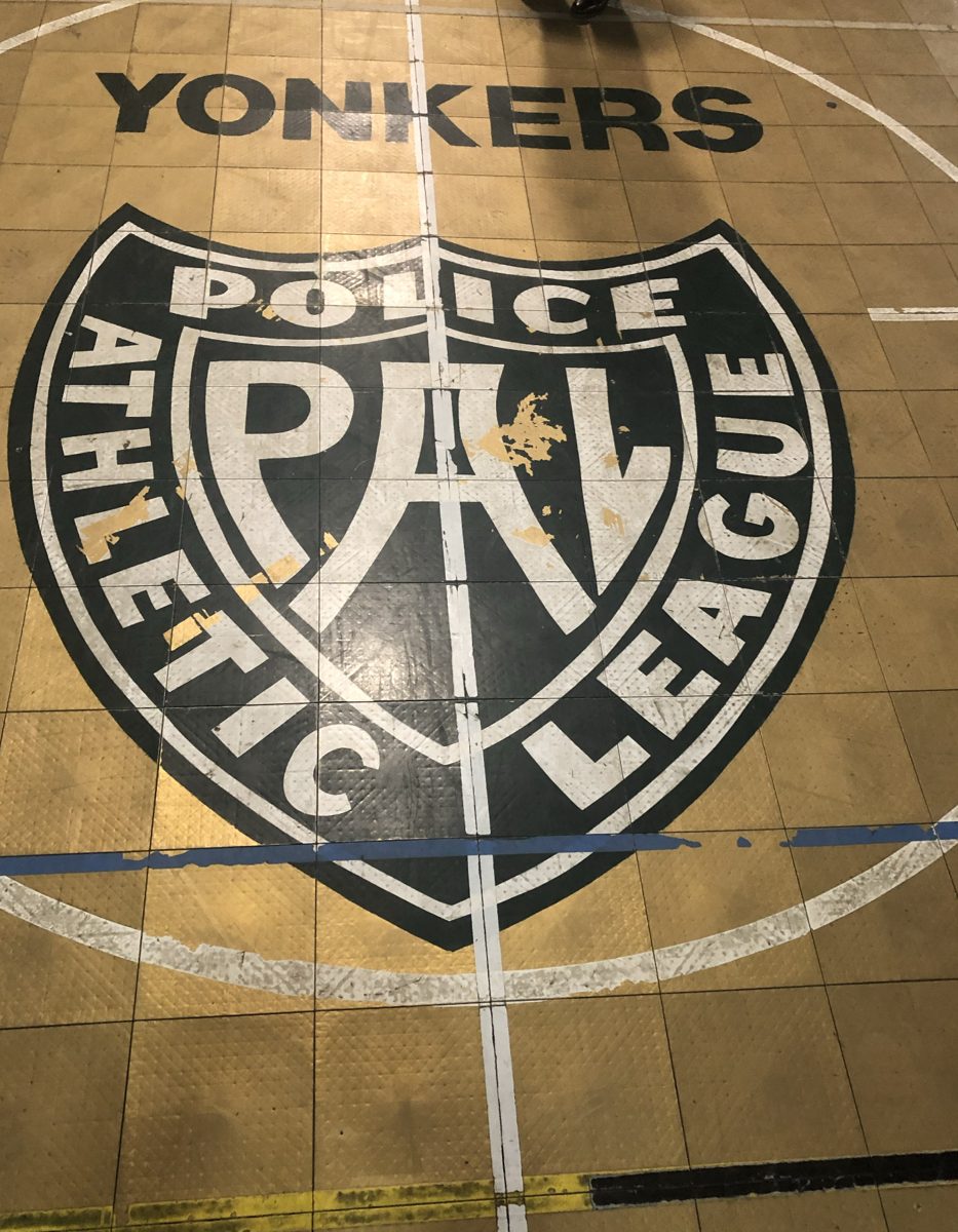 Worn Yonkers Police Athletic League logo painted on the old tile floor