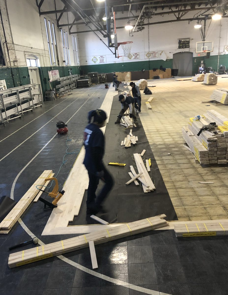Crew laying underlayment and the first rows of new hardwood