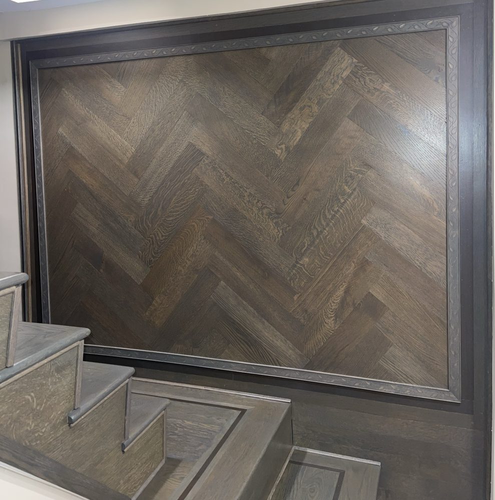 Dark herringbone wood wall panel with matching stained stairs
